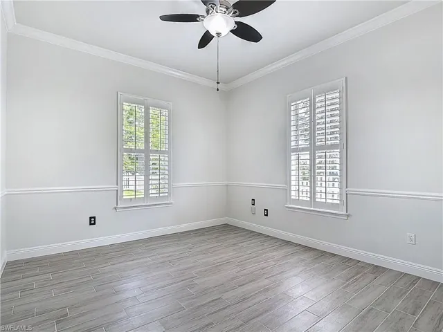 Empty room featuring crown molding, wood finish floors, and ceiling fan