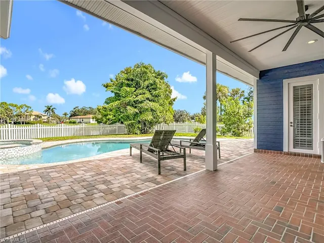 View of pool with a patio area, a fenced backyard, a pool with connected hot tub, and ceiling fan