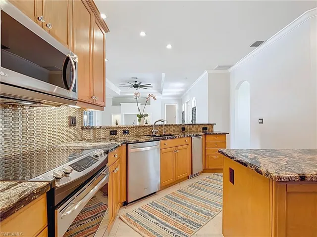Kitchen with crown molding, stainless steel appliances, recessed lighting, backsplash, and arched walkways