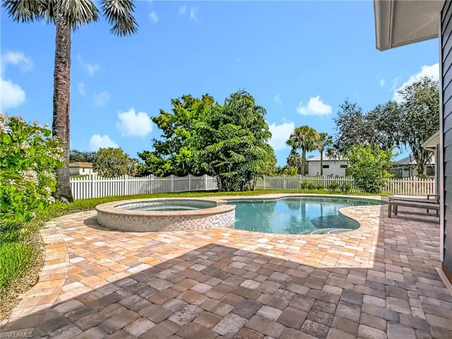 View of swimming pool featuring a patio, a fenced backyard, and a pool with connected hot tub