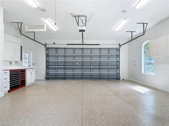 Garage featuring baseboards and a garage door opener