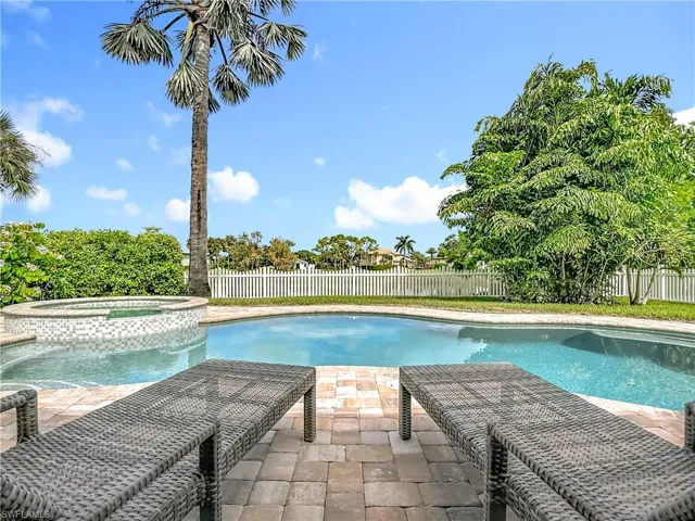 View of swimming pool featuring a fenced backyard, a patio area, and a pool with connected hot tub