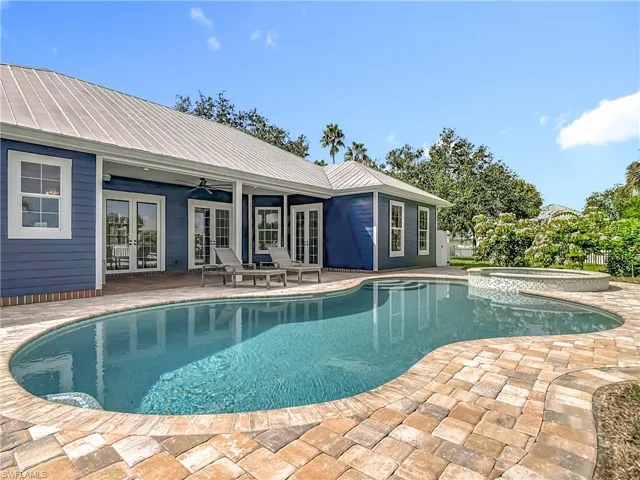 View of pool with french doors, a patio area, a ceiling fan, and a pool with connected hot tub