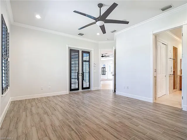 Unfurnished room featuring crown molding, light wood-type flooring, recessed lighting, a ceiling fan, and french doors