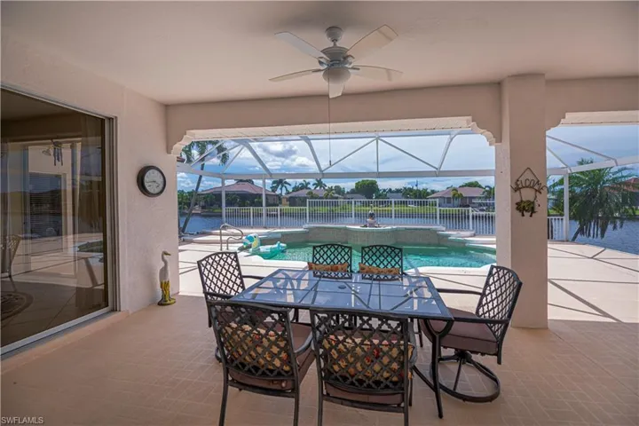 under covered lanai area looking out to pool and canal