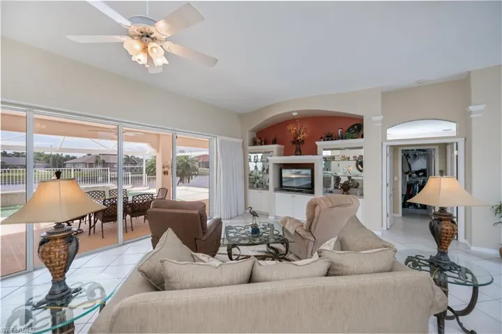 great room looking at lanai/pool/water view to the left and entrance to the master suite to the right