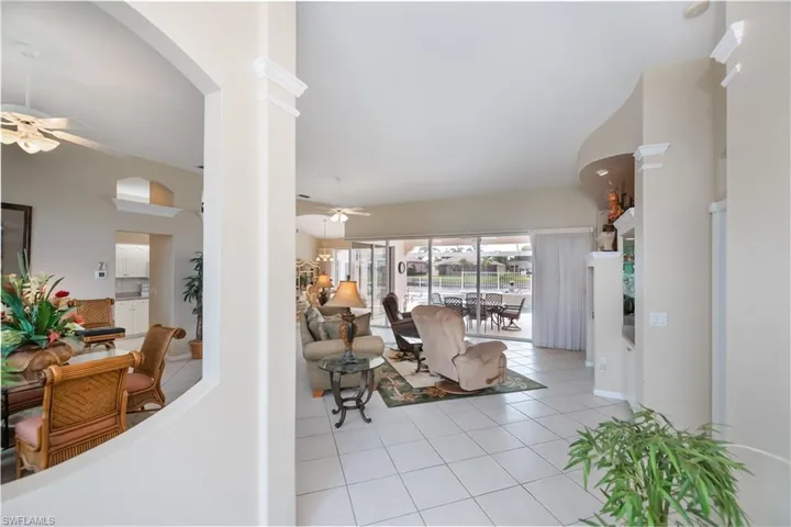 entrance looking into great room and dining room and view of pool and water view