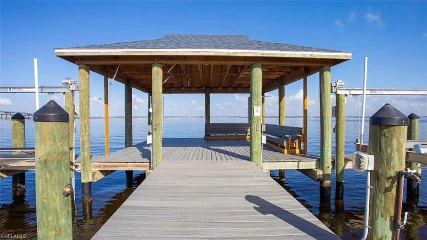 Dock area featuring boat lift and a water view
