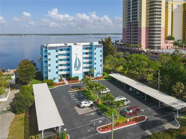 Drone / aerial view of apartment complex / building and a nearby body of water