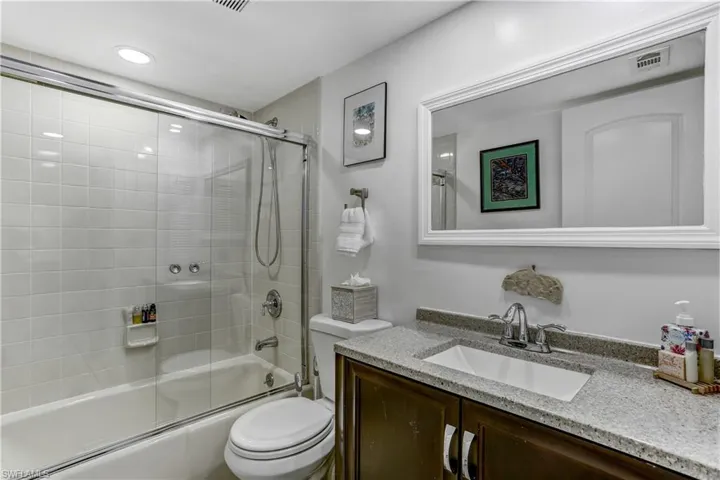 Full bath with vanity and combined bath / shower with glass door