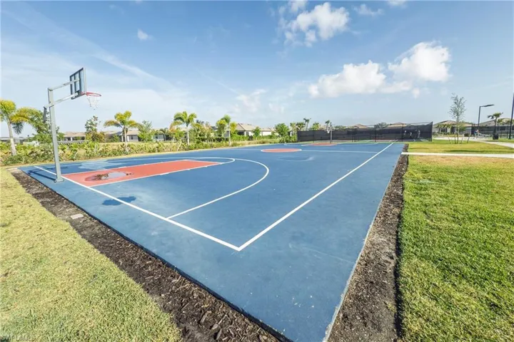 View of sport court featuring a lawn, fence, and community basketball court