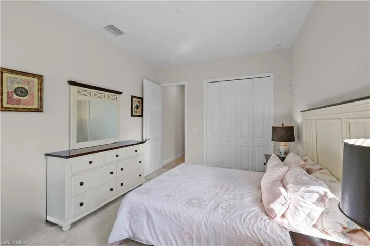 Bedroom with light carpet, a closet, and visible vents
