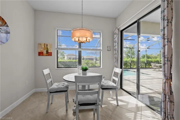 Dining area with baseboards, a notable chandelier, and light tile patterned floors