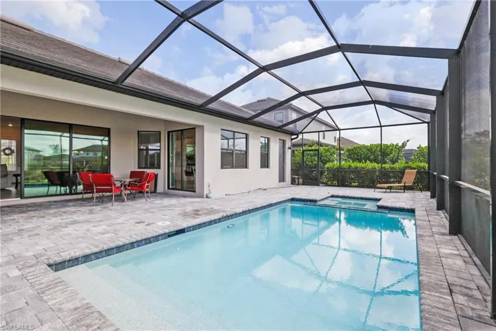 View of swimming pool with a patio, a pool with connected hot tub, and a lanai