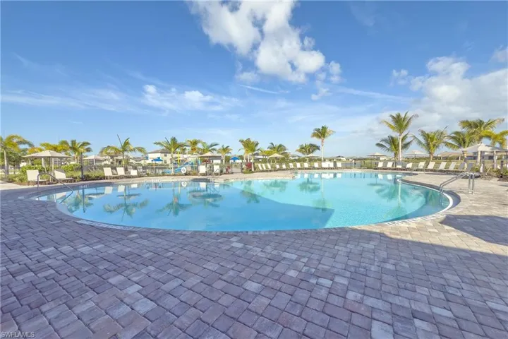 Community pool featuring a patio and fence
