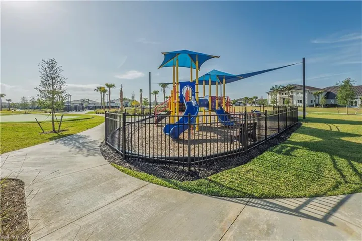 Communal playground featuring a yard and fence