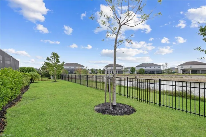 View of yard featuring fence, a water view, and a residential view