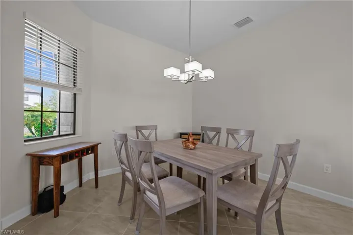 Dining room with a chandelier, light tile patterned floors, visible vents, and baseboards