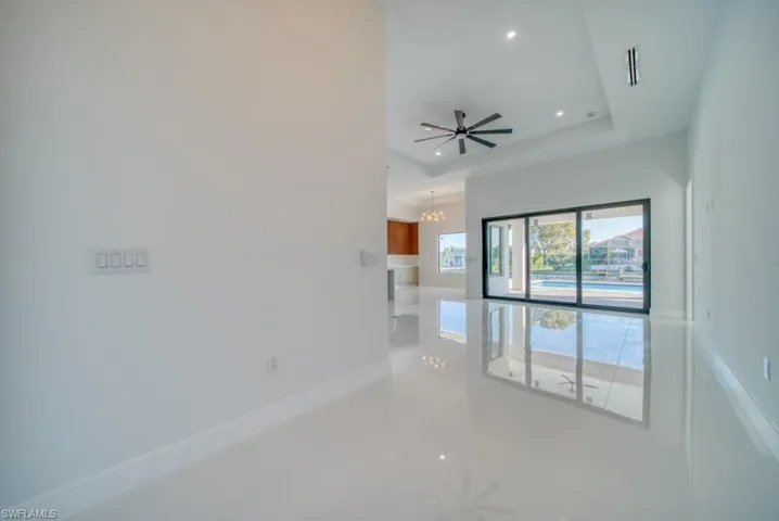 Spare room featuring ceiling fan, a raised ceiling, a chandelier, and recessed lighting