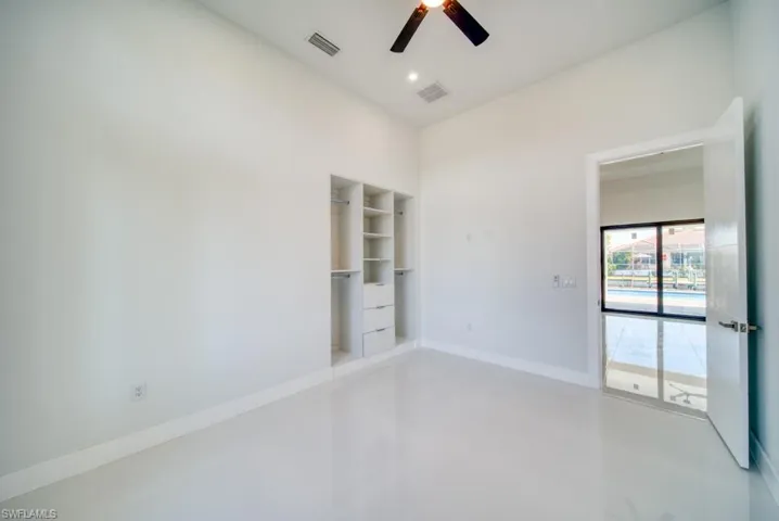 Unfurnished room featuring finished concrete flooring and a ceiling fan