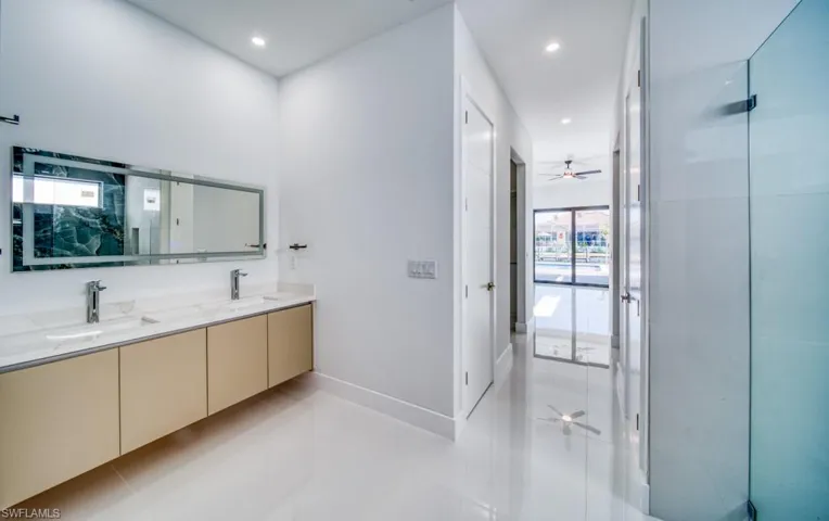 Bathroom featuring double vanity, a ceiling fan, recessed lighting, a stall shower, and light tile patterned flooring