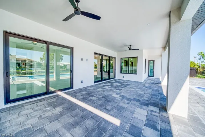 View of patio / terrace with ceiling fan and a pool with connected hot tub