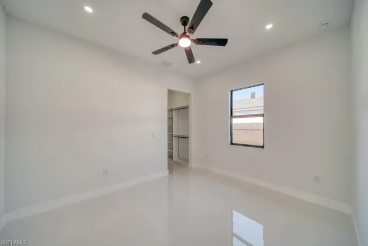 Unfurnished bedroom featuring a spacious closet, a ceiling fan, and recessed lighting