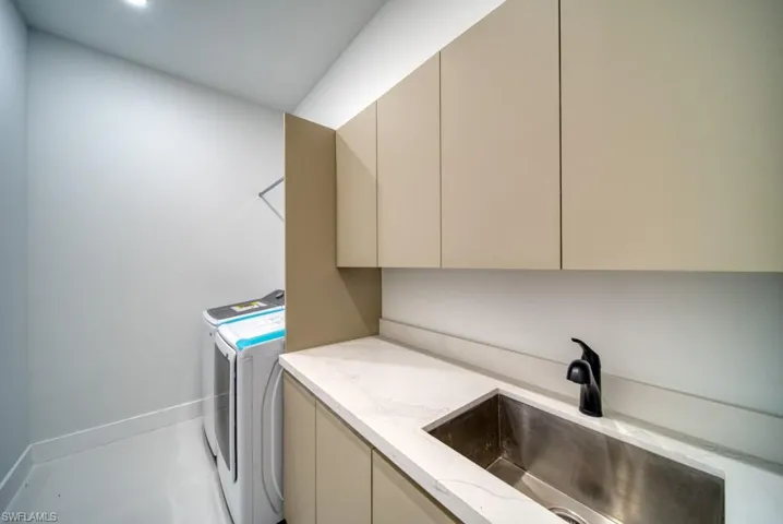 Laundry room featuring independent washer and dryer and cabinet space