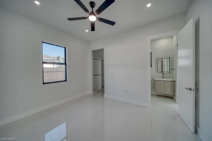 Unfurnished bedroom featuring a ceiling fan, connected bathroom, and recessed lighting
