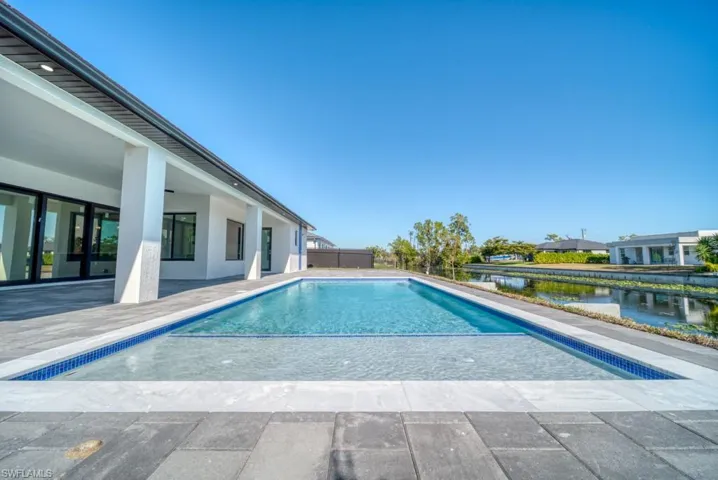 Outdoor pool featuring a patio and a water view