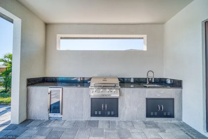 View of patio with area for grilling and a sink