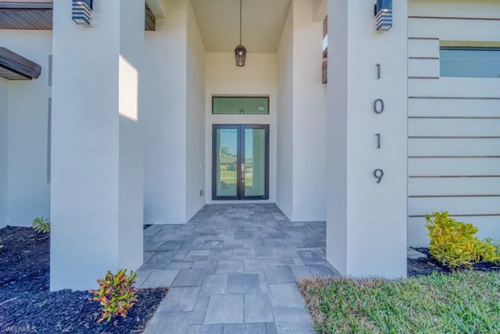 Entrance to property featuring stucco siding and french doors