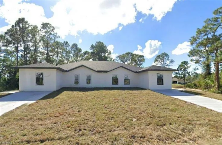 Ranch-style house featuring stucco siding and a front yard