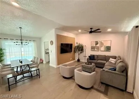 Open-concept living space with vaulted ceilings, recessed lighting, and tile flooring