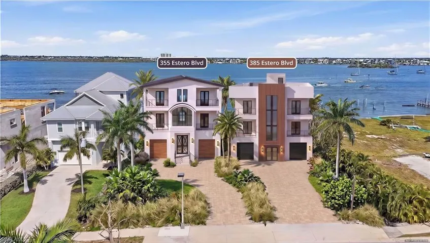 Waterfront property with multiple residential structures, mature palm trees, paved driveways, and lush landscaping - Virtually Edited Image
