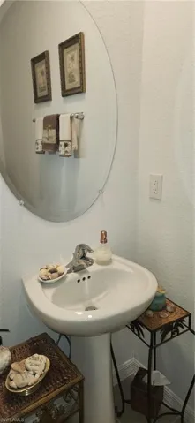 Bathroom with a textured wall and baseboards