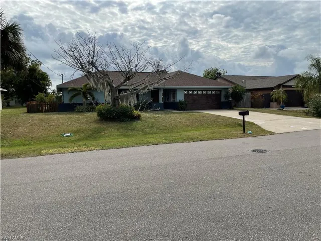 Single story home featuring a front yard and a garage