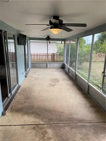 Unfurnished sunroom featuring ceiling fan