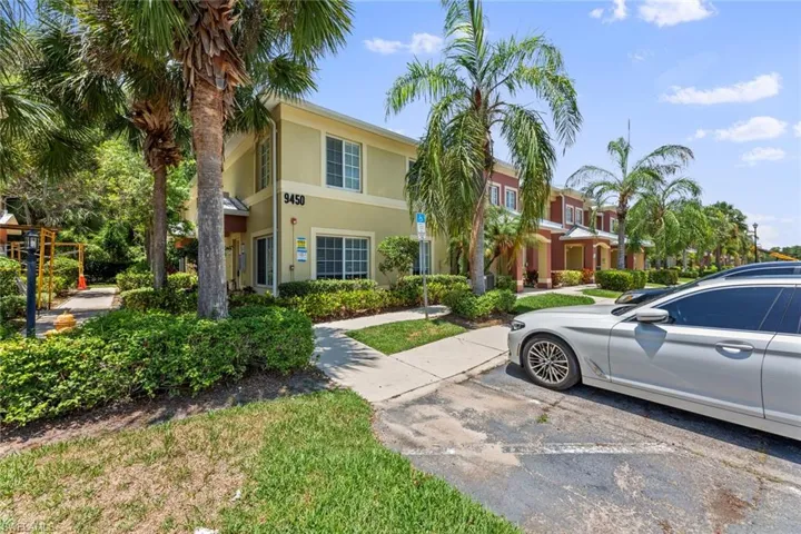 View of property featuring uncovered parking and stucco siding