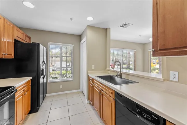 Kitchen with black appliances, healthy amount of natural light, light countertops, and recessed lighting
