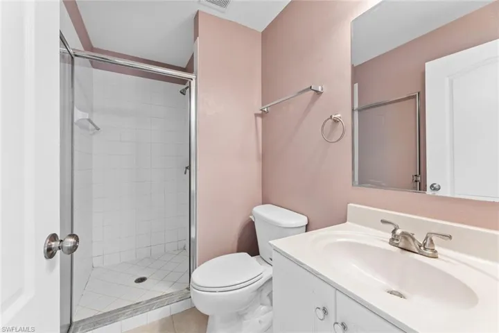 Full bathroom featuring a stall shower, vanity, and tile patterned flooring