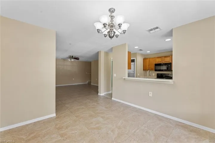 Unfurnished living room with a chandelier, ceiling fan, and recessed lighting