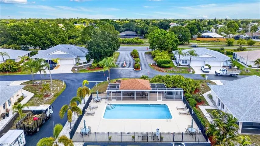 Community swimming pool featuring a concrete deck and a covered pavilion with a shingled roof