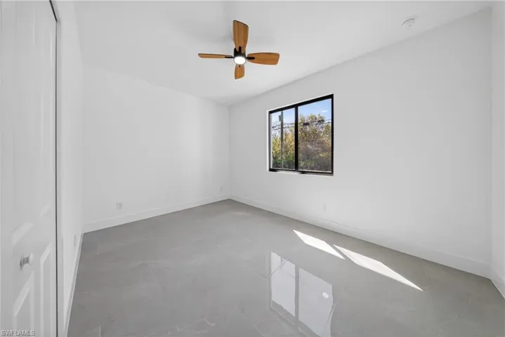 Empty room featuring baseboards and a ceiling fan