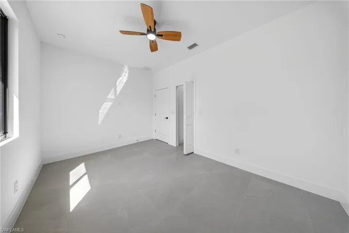 Unfurnished bedroom with a ceiling fan and multiple windows
