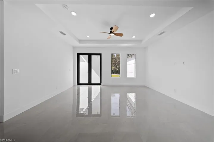 Unfurnished room featuring a tray ceiling, ceiling fan, and recessed lighting