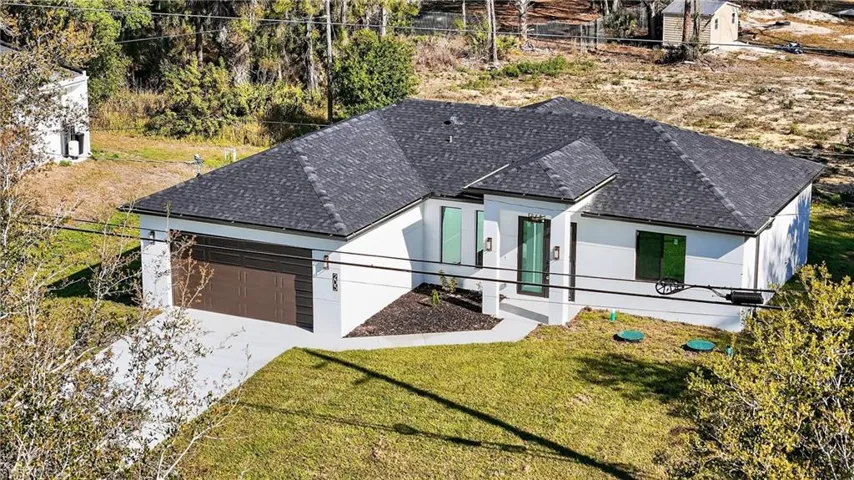 View of front of home featuring a shingled roof, a garage, and driveway