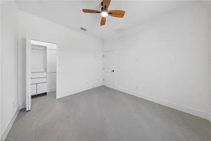 Unfurnished bedroom featuring baseboards and ceiling fan