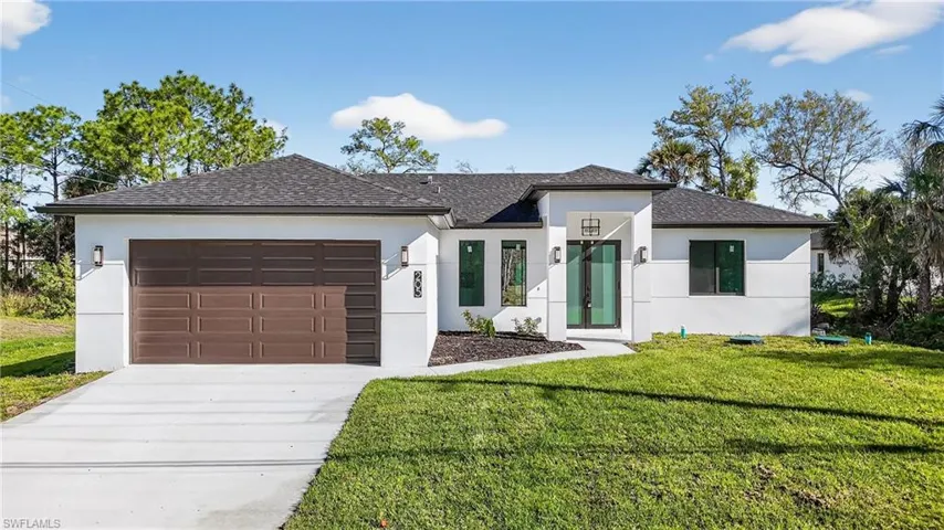 View of front of home featuring stucco siding, an attached garage, concrete driveway, a front yard, and roof with shingles