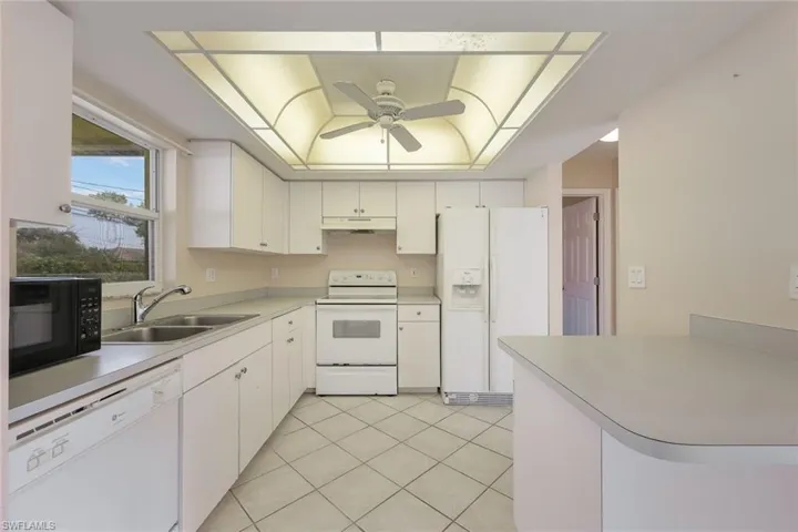 Kitchen with sink, white appliances, and white cabinets